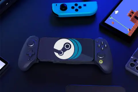 Smartfon z logo Steam w uchwycie gamingowym, idealny do grania w gry z PC na Androidzie. Obok kontroler i ekran z grą retro.