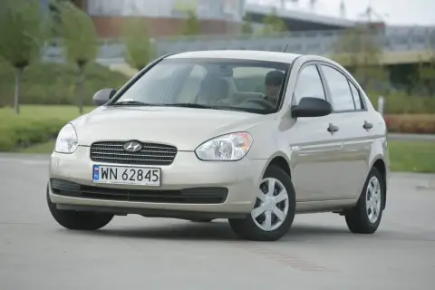 Złoty Hyundai Accent z polskimi tablicami WN 62845 zaparkowany na zewnątrz.