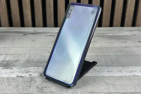 Telefon Samsung Galaxy A50 na czarnym stojaku, z widocznym logo Samsung. Sprawdź aktualną samsung galaxy a50 cena.