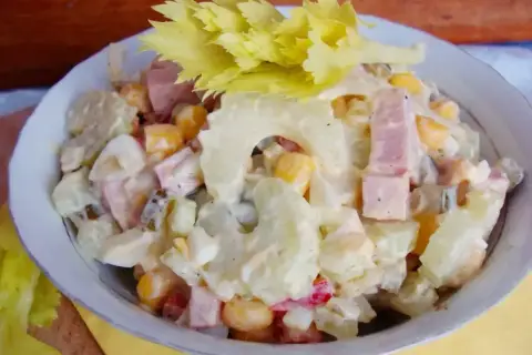 Sałatka z selerem naciowym, jajkiem, kukurydzą i szynką w sosie majonezowym.