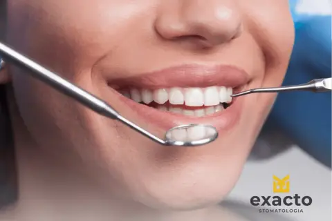 Uśmiechnięta pacjentka podczas wizyty w Exacto Stomatologia. Dentysta bada jej zdrowe zęby.