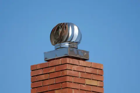 Metalowa nasada komina z wirującym elementem, zapewniająca sprawną wentylację hybrydową.