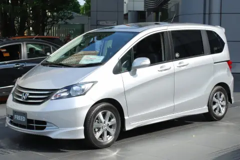 Srebrny Honda Freed stoi na tle budynku.