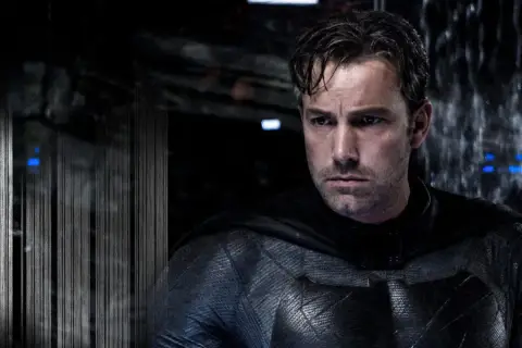 Ben Affleck jako Batman, w swoim charakterystycznym kostiumie, spogląda w dal.