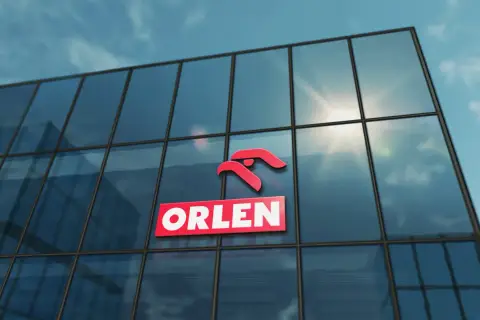 Logo ORLEN na szklanym budynku, symbolizujące najlepsze inwestycje.