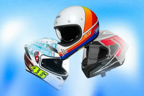 Tre caschi da moto con grafiche diverse, uno bianco con strisce colorate, uno bianco con disegno invernale e il numero 46, e uno grigio con dettagli rossi. La normativa casco moto è fondamentale per la sicurezza.