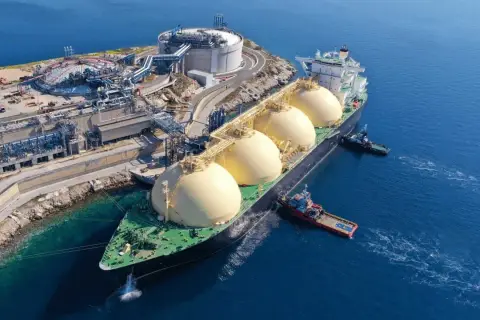 Statek z kulistymi zbiornikami LNG przy terminalu, symbolizujący zmianę dostawcy gazu.