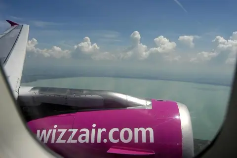 Widok z okna samolotu Wizzair na jezioro i chmury. Zastanawiasz się, ile kosztuje wybór miejsca w Wizzair?