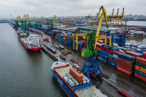 Port z dźwigami i kontenerami, gotowy do załadunku na statki. Dokumentacja celna, czyli morski list przewozowy, czeka na wypełnienie.
