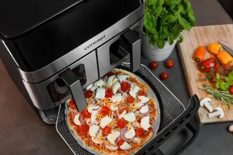 Gotowa do pieczenia pizza w air fryerze. Pyszna, domowa pizza z pomidorami i mozzarellą w zasięgu ręki dzięki nowoczesnemu urządzeniu.