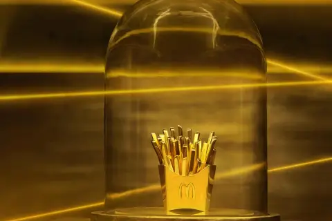 Złote frytki z McDonald's pod szklaną kopułą, jak nagroda w loterii.