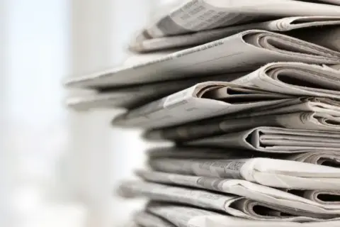 Stos gazet, symbolizujący branżę wydawniczą, czeka na skutki zmian w prawie autorskim w 2026 roku.
