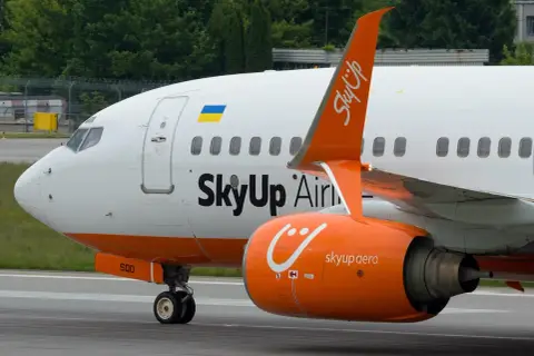 Samolot SkyUp Airlines z pomarańczowym silnikiem i charakterystycznym logo.