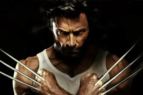Wolverine po polsku, z pazurami wysuniętymi, w białej podkoszulce, patrzy groźnie.