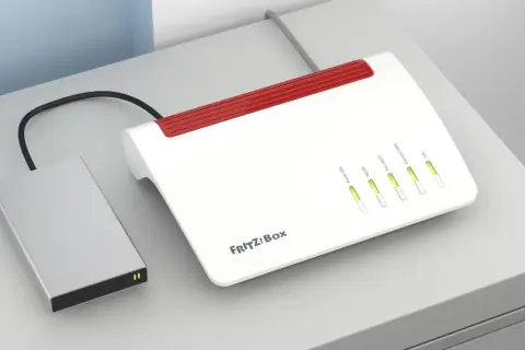 Eine externe Festplatte ist über ein Kabel mit einer FRITZ!Box verbunden, um Daten im Netzwerk zu teilen.