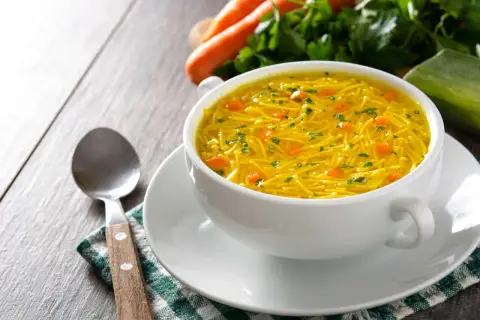 Aromaticzny rosół z makaronem, z kawałkami marchewki i natką pietruszki. Idealny na lekki posiłek, z niską zawartością kcal.