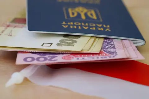 Ukraiński paszport z pieniędzmi, symbolizujący nadzieję na godną emeryturę dla Ukraińców.