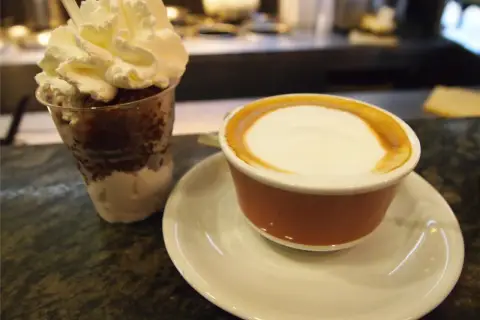 Deser z bitą śmietaną i kawa latte, jakby zrobione z tazza d'oro.