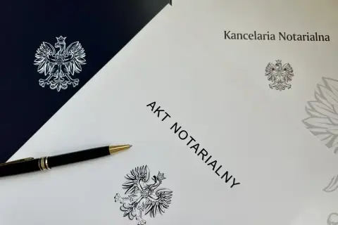 Akt notarialny na najem okazjonalny czeka na podpis. Długopis i orzeł w koronie symbolizują formalność i bezpieczeństwo transakcji.