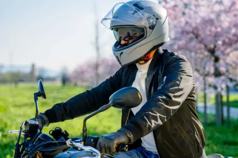 Motociclista con casco grigio, pronto per un giro. La scelta del giusto **misura casco moto** è fondamentale per la sicurezza.