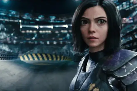 Alita Battle Angel 2: Alita w zbroi, z wielkimi oczami, stoi na arenie, gotowa do walki.