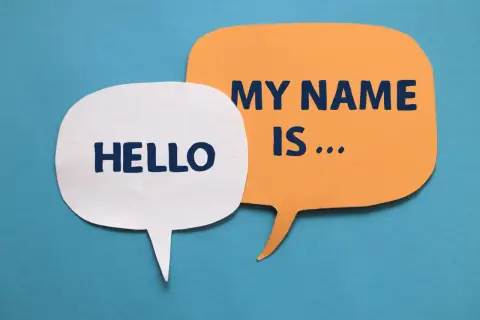 Dwie dymki: biała z napisem "HELLO" i pomarańczowa z "MY NAME IS...". Idealne do nauki angielskich imion męskich.