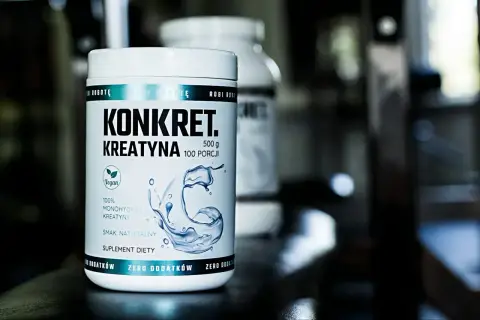 Biały słoik z napisem "KONKRET. KREATYNA" i grafiką wody. To suplement diety, jaka kreatyna dla Ciebie?