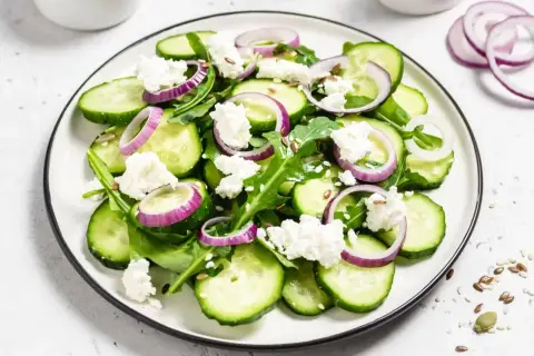 Świeża sałatka z ogórków, rukoli, sera feta i czerwonej cebuli. Idealny przepis na lekkie danie.
