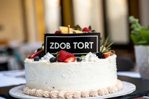 Elegancki tort dla 14 latki, ozdobiony świeżymi owocami i napisem "Zdob Tort". Idealny na wyjątkową okazję.