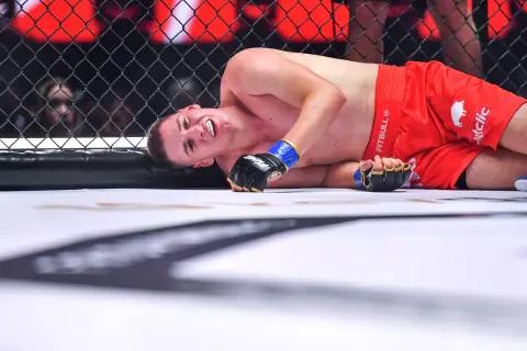 Zawodniczka MMA leży na macie, z grymasem na twarzy. Czy ma tyle lat, ile ostry od czajnika?