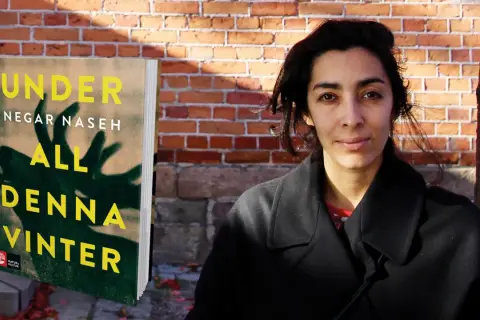 Negar Naseh poserar bredvid sin bok "All denna vinter".