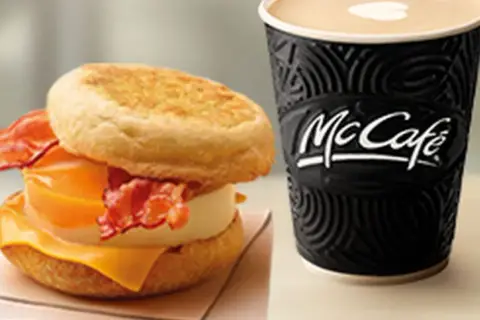 McMuffin z jajkiem, serem i bekonem obok kubka McCafe. Idealny zestaw na śniadanie.
