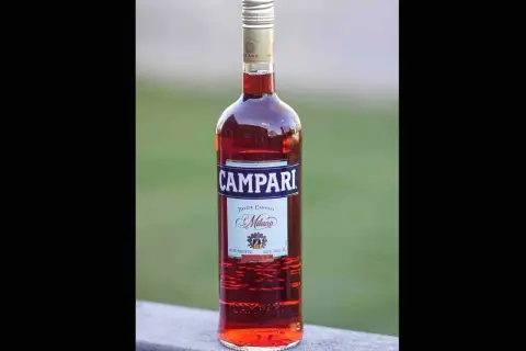 Butelka czerwonego likieru Campari z etykietą "Davide Campari Milano".