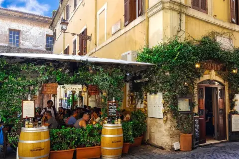 Un charmant restaurant à Rome, "Antica Osteria Rugantino", envahi par la végétation. Idéal pour savoir où manger à Rome.
