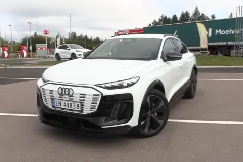 Białe Audi Q6 e-tron na parkingu. Zastanawiasz się nad audi q6 e-tron cena? Sprawdź, czy warto!