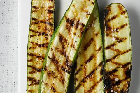 Courgettes grillées au barbecue, légèrement salées, parfaites après une marinade savoureuse.