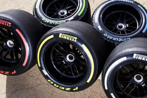 Pięć opon Pirelli F1 z kolorowymi paskami na bokach: czerwonym, żółtym, niebieskim, zielonym i białym.