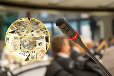 Ile zarabia radny w Warszawie? Na stole leżą banknoty 200 zł, a przed mikrofonem siedzą ludzie.
