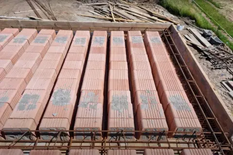 Strop ackermana w budowie, z pustaków ceramicznych ułożonych na żebrach zbrojeniowych, gotowy do zalania betonem.