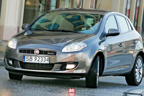 Szary Fiat Bravo 2 z tablicą rejestracyjną SB 92334 na tle budynku.
