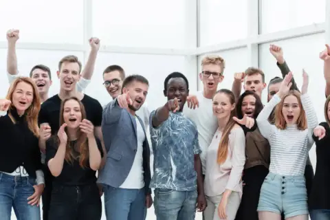 Grupa młodych ludzi z entuzjazmem pozuje do zdjęcia. Ich pozytywne emocje i okrzyki mogą być odzwierciedleniem dobrych **uniwersytet ekonomiczny w krakowie opinie**.