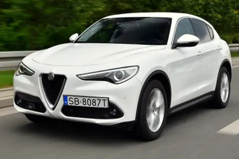 Białe Alfa Romeo Stelvio w ruchu. Kierowcy chwalą jego dynamikę, co potwierdzają liczne alfa romeo stelvio opinie.