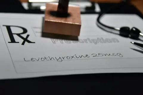 Recept na leki, na którym widnieje "Levothyroxine 25mcg". Obok stetoskop i pieczątka.