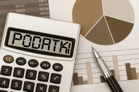 Kalkulator z napisem "PODATKI" na tle wykresów i tabel. Obraz sugeruje analizę, od jakiej kwoty płaci się podatek od sprzedaży.