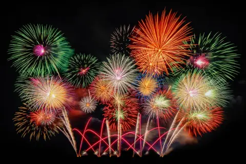 Ein farbenprächtiges Feuerwerk erhellt den Nachthimmel, wie es typisch für Silvester in Deutschland ist.