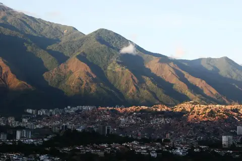 Góry otaczają Caracas, stolicę Wenezueli. Widać gęsto zabudowane wzgórza i nowoczesne budynki.