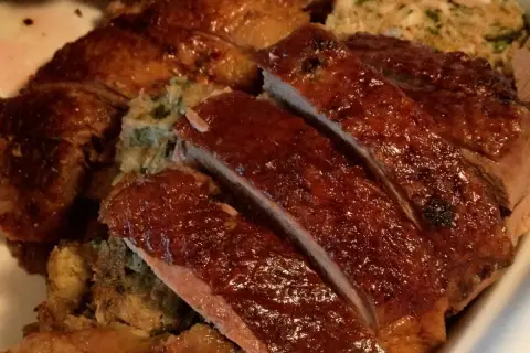 Gęś Ania gotuje. Pyszna, pieczona gęś z chrupiącą skórką i aromatycznym farszem, pokrojona na kawałki.