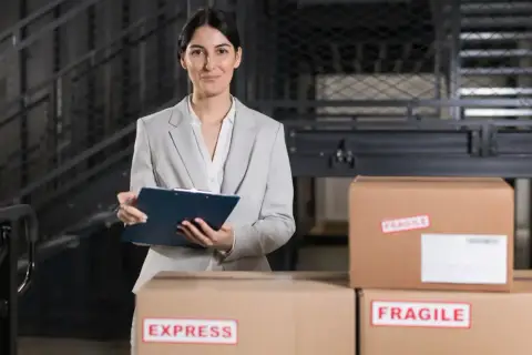 Agent celny z notatnikiem w ręku nadzoruje przesyłki, w tym oznaczone jako "EXPRESS" i "FRAGILE".