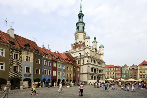 Kolorowy Rynek w Poznaniu, jedno z miejsc, które pokazują, jakie miasta warto zwiedzić w Polsce. Tętniący życiem plac z ratuszem i kamieniczkami.