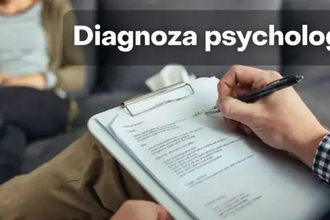 Psycholog diagnosta notuje podczas sesji. Na pierwszym planie dłoń pisząca na kartce, w tle siedząca osoba.